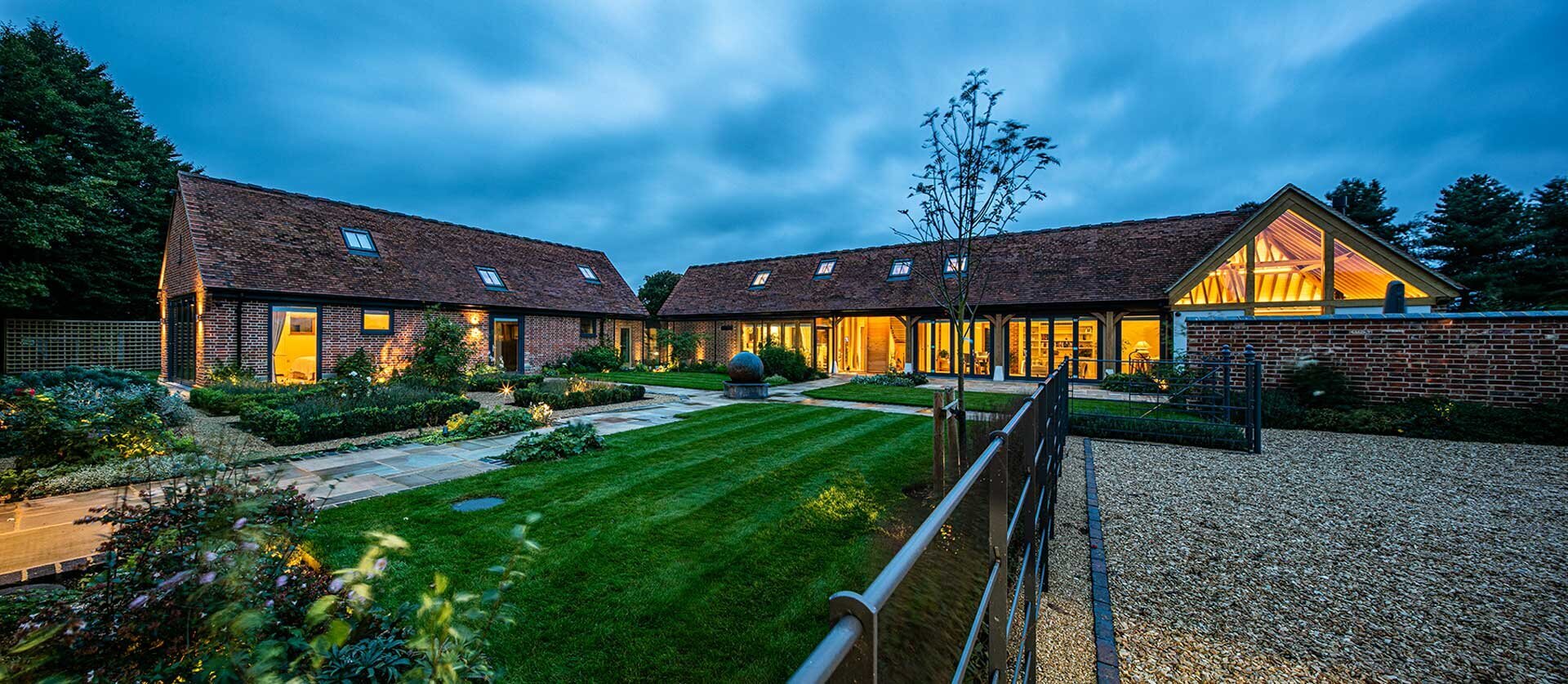 An image of a traditional barn conversion with anthracite grey aluminium clad timber composite windows